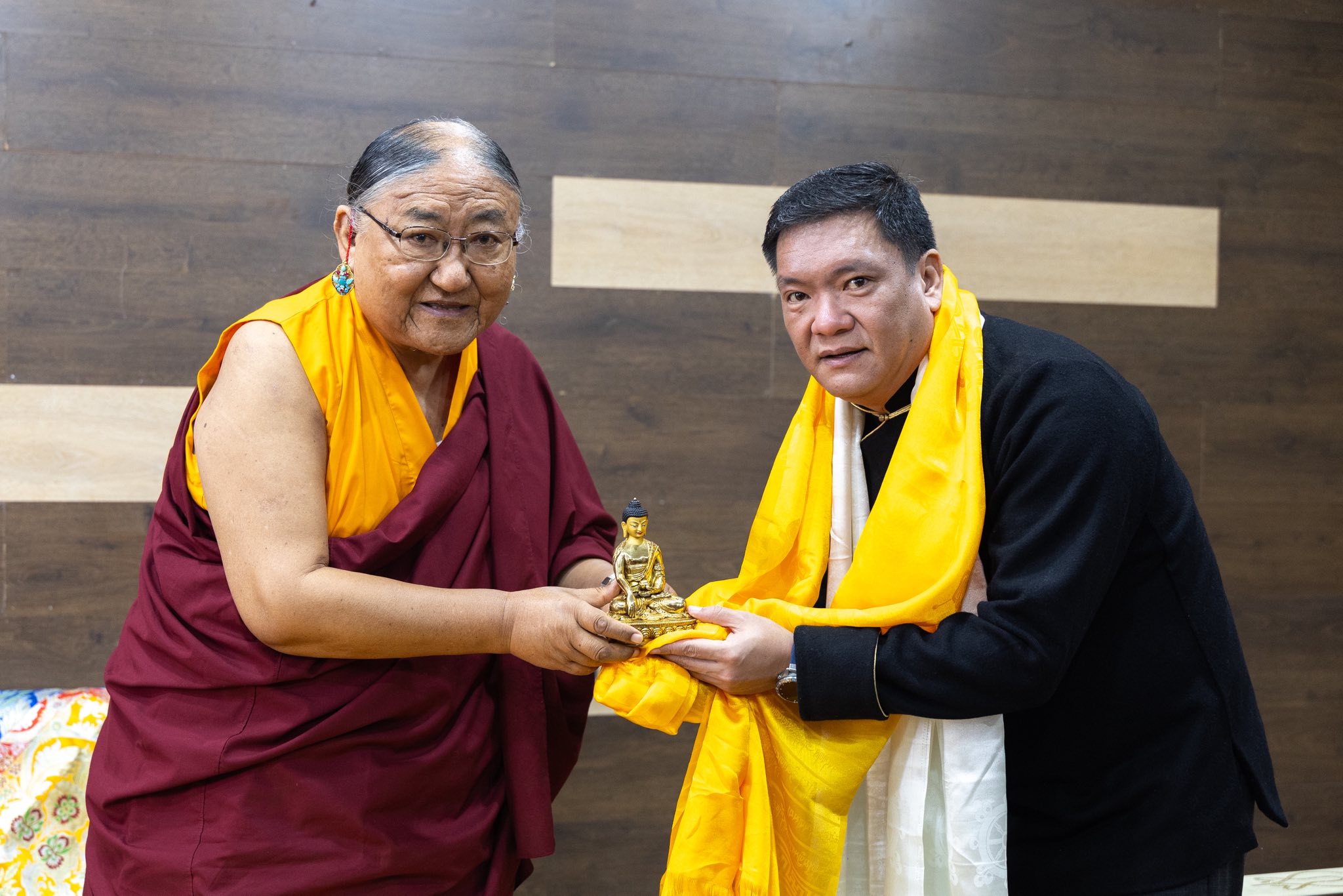 His Holiness the 41st Sakya Trizin presenting a golden Buddha statue to a dignitary, demonstrating the cross-cultural bridge-building that characterizes his global mission